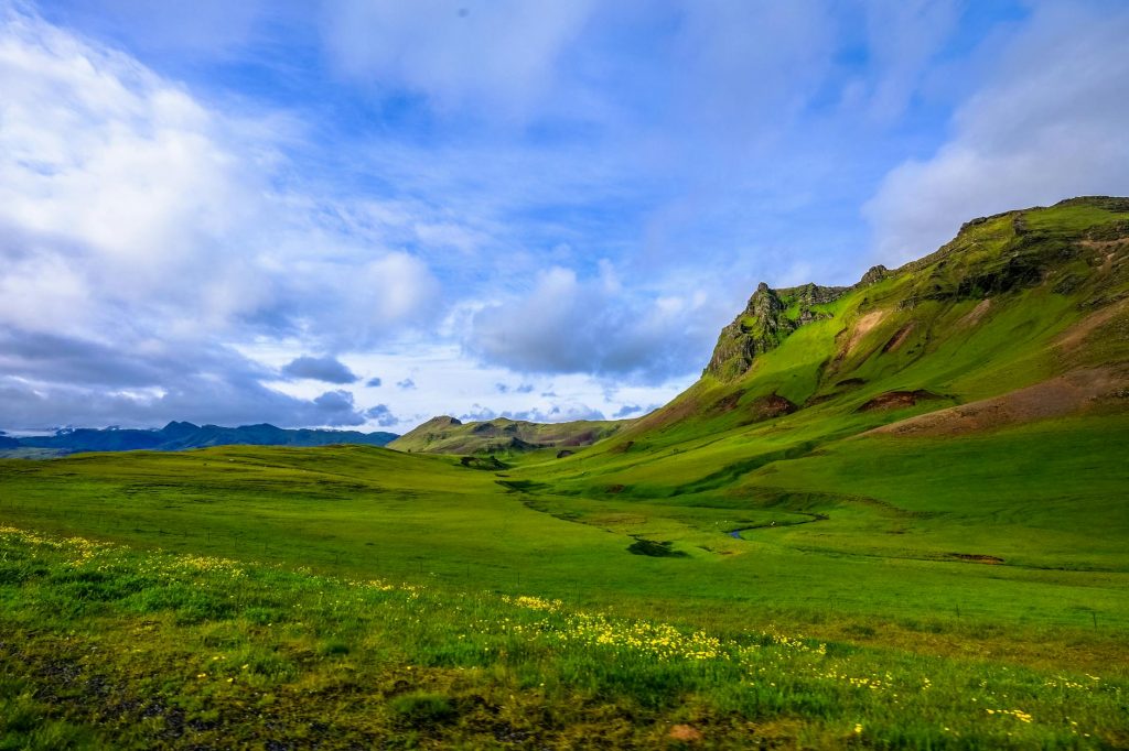 Rolling green hills beneath blue sky